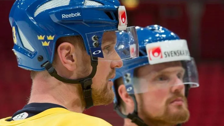Team Sweden Henrik Sedin, left, and his brother Daniel listen to the coach during a practice session, Wednesday, May 15, 2013 at the world hockey championship in Stockholm Sweden. Sweden will play Canada in the quarter finals Thursday May 16.  (AP Photo/The Canadian Press, Jacques Boissinot)