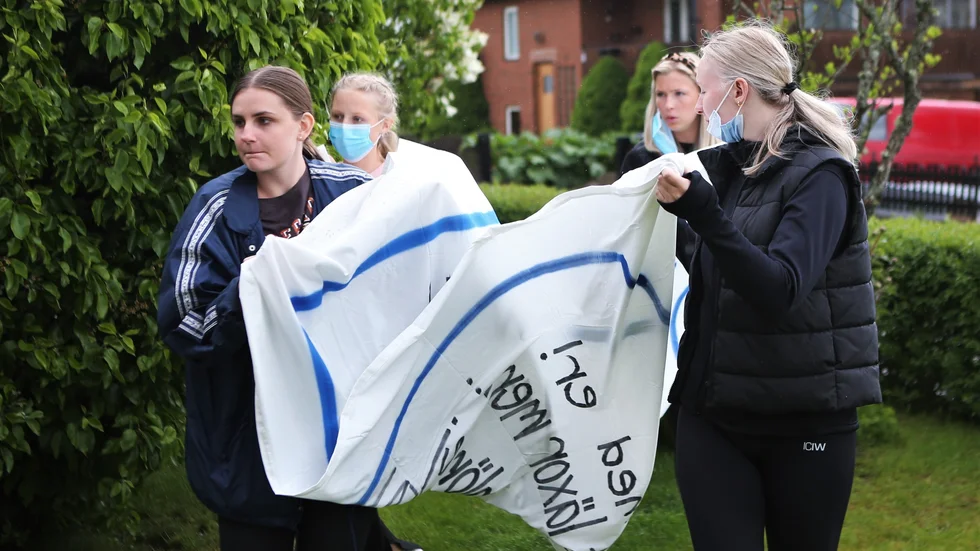 Naturklassen Na19a är ute i god tid med att förbereda sitt studentflak. Ett av lakanen som ska hänga på flaket har här blivit färdigt och ska bäras iväg för torkning. 