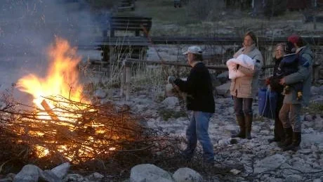 En familj med barn tittar på när pappa tänder valborgsmässoelden.
(personerna på bilden har inget med artikeln att göra).
