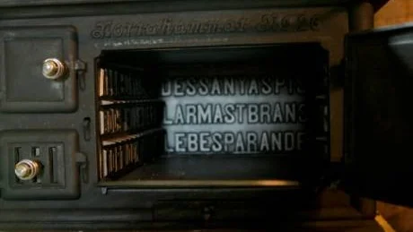 ÖPPEN. Äldre spis med text inuti.