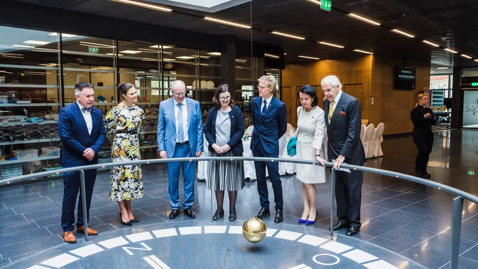 I den höga entréhallen finns en Foucaultpendel. Johan Tysk, vicerektor, kronprinsessan Victoria, universitetets rektor Anders Hagfeldt, utbildningsminister Anna Ekström, landhövding Göran Enander, konsistoriets ordförande Anne Ramberg och affärsmannen Anders Wall tittar intresserat.