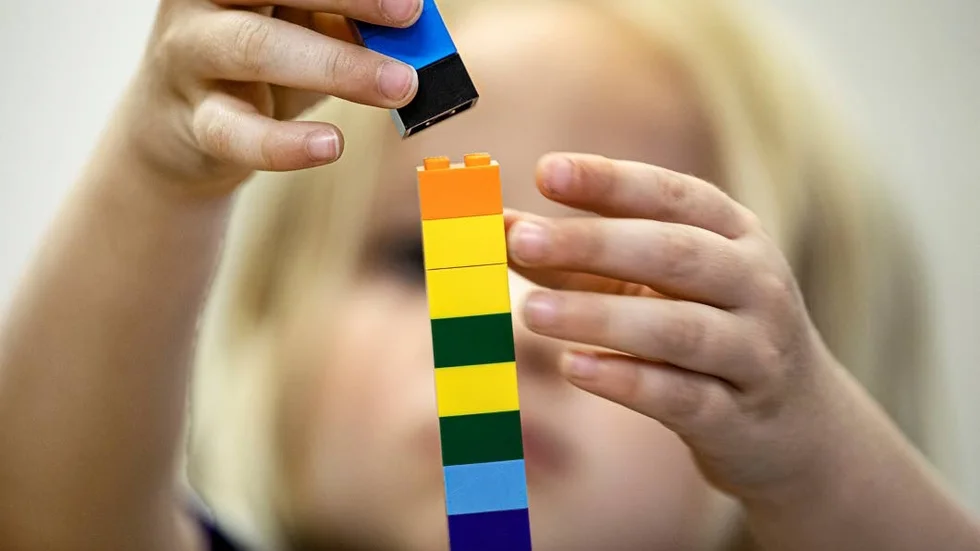 Legoklossar som staplas av ett lekfullt barn.
