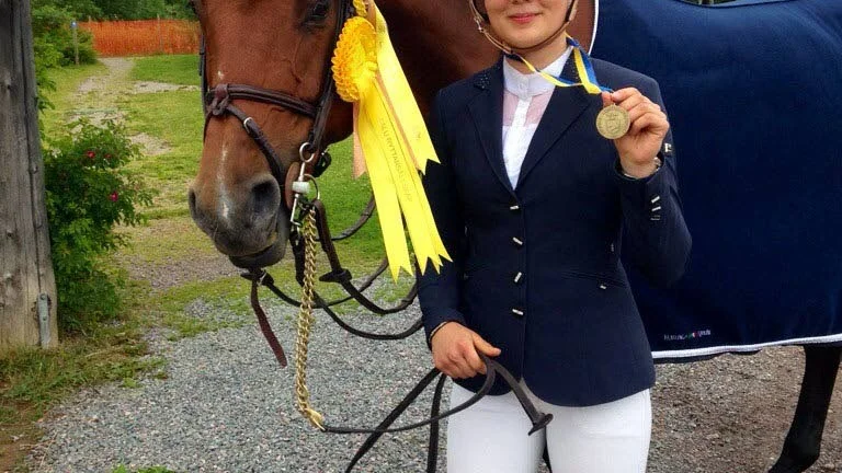 En mycket glad Hilda Öhman visar upp bronsmedaljen från SM i hästhoppning. Hon var jättenöjd över Corradinas insats.