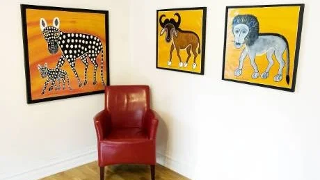 Leopard med unge, buffel och lejon. Tre TingaTinga-målningar av skaparen Edward Saidi Tingatingas som Dandi som finns med på utställningen i GalleriLi i Skärkind.