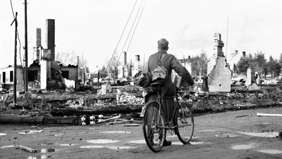 En soldat med cykel vid korsningen av Rovakatu och Hallituskatu (Regeringsgatan) i nordfinska staden Rovaniemi som ligger i ruiner efter tyska bombningar under andra världskriget 1944.