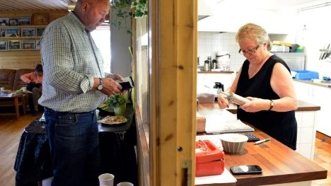 Bengt Sundgren betalar loppisfyndet, en degsprits till före detta klasskamraten och loppmarksföreståndaren Britt-Marie Marklund.