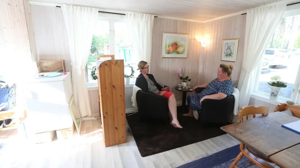 Samtal i stugan. I förgrunden det gamla slagbordet som under årens lopp stått i centrum för många samtal.