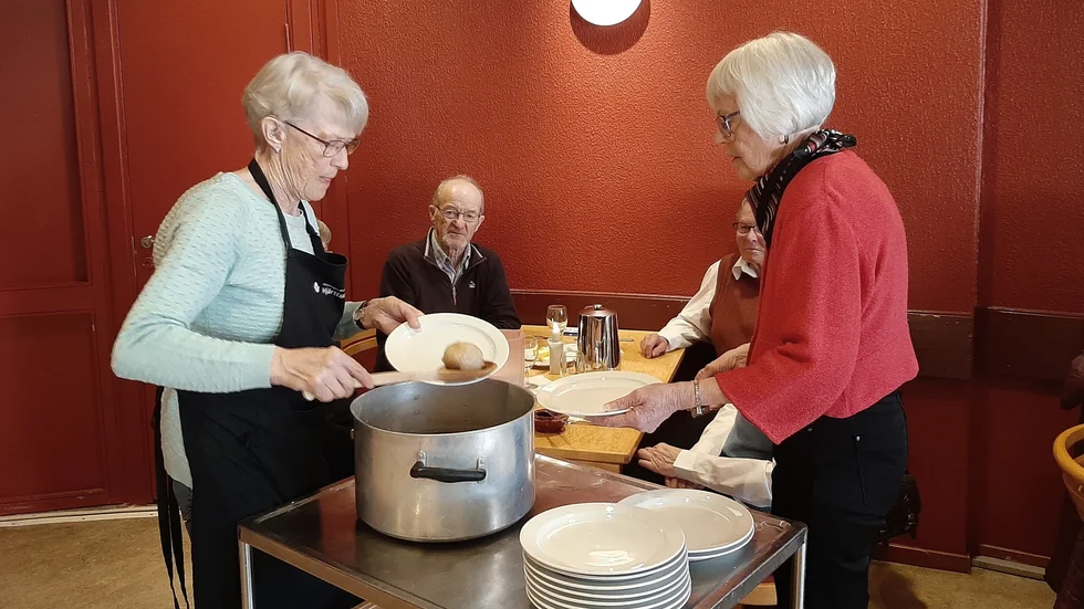Yvonne Lenman och Hjördis Eklund serverar hemlagad palt till bland andra Ossian Lundberg.