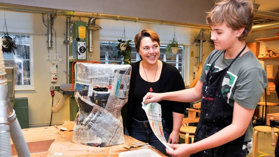 Maria Annögård är lärare i trä- och metallslöjd på Vallonskolan i Gimo. Här i samspråk med Emil Ingebo Haglund i klass 9A under en av de lektioner då eleverna får bygga på sina knutmassodräkter.