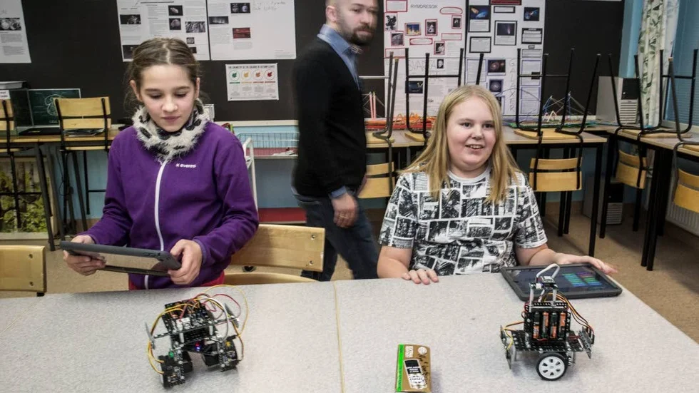 Idde Österman och Lukas Nejdling i klass 7D på Gränbyskolan granskar sina robotar inför veckans fotbollsturnering. I bakgrunden syns läraren Magnus Blom.