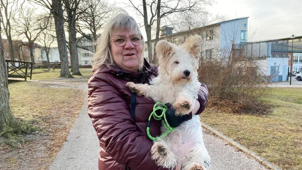 Helén Sjöberg med hunden Yoshi. Hon har precis kastat en liten grön påse.