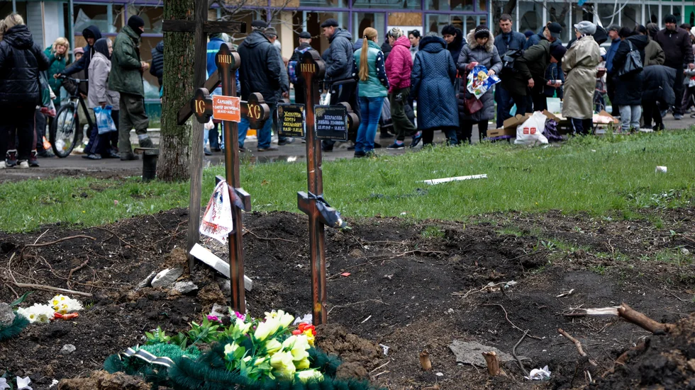 Arkivbild på två nygrävda gravar i Mariupol i april.