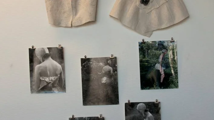 Kläderna är hängda på enkla trådgalgar, kompletterat med bilder av modeller med kläderna.