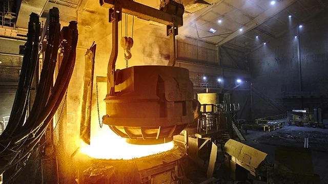 Chargering (insättning) av skrot vid ljusbågsugn. Skrotkorgen är på väg att öppna och släppa ned 70 ton skrot.