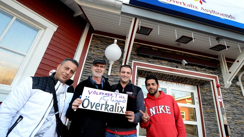 VÄLKOMNAS. Maat Masaabs, Omer Adnan och Karam  Al-Qado hälsas välkommen av överkalixbon och MP-politikern Kennerth Moberg som hade tillverkat en välkommenskylt.?