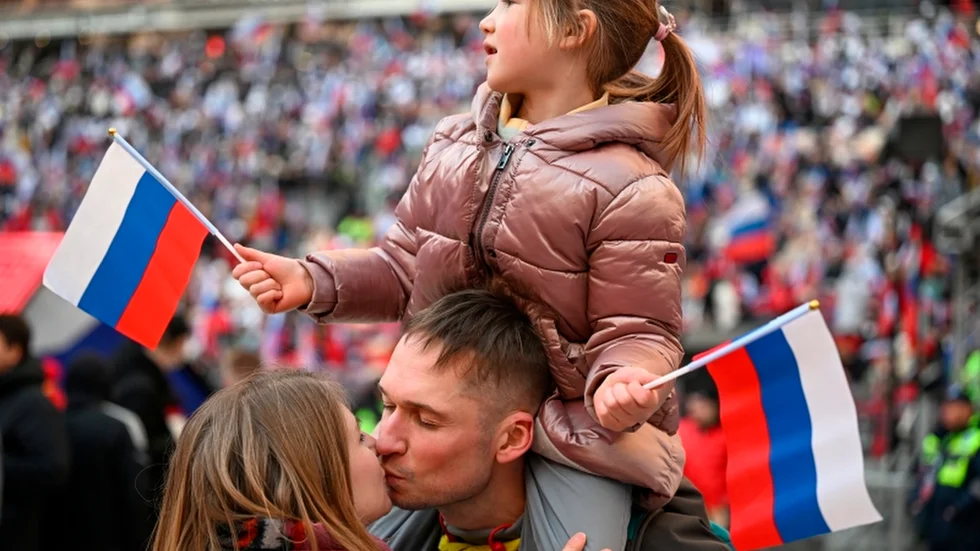Ett ungt par kyssar varandra under en patriotisk konsert i Moskva i mars 2022.