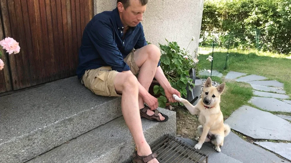 Anders Jansson och familjens valp Eira, en norsk buhund.