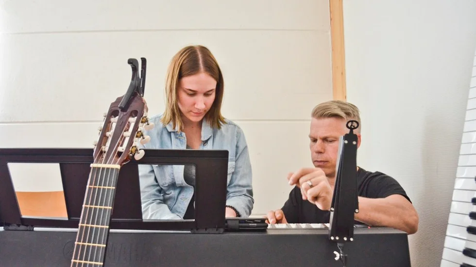 Johan Löfcrantz Ramsay på Öppna Kulturskolan hjälper Iina Ahopelto med en kompletteringsuppgift till skolmusiken. – De har lärt oss att tro på oss själva, säger Iina.