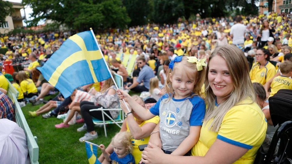 Melissa Rundström och Emma Rundström flaggar för Sverige i Stadsparken i Katrineholm