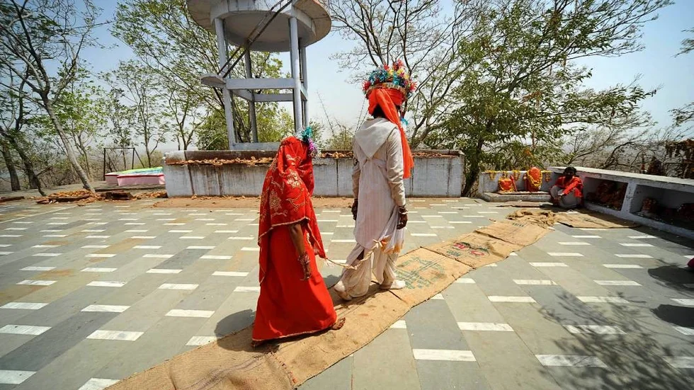 An under-age newly married couple who refused to be identified, walk to the temple to seek the blessings of a priest after a mass marriage at Chachoda village in Rajgarh town, about 155 kilometers (96 miles) from Bhopal, India, Sunday, May 16, 2010. Even though child marriages are illegal in India, they are still held particularly in small poverty stricken villages.( AP Photo/Prakash Hatvalne)