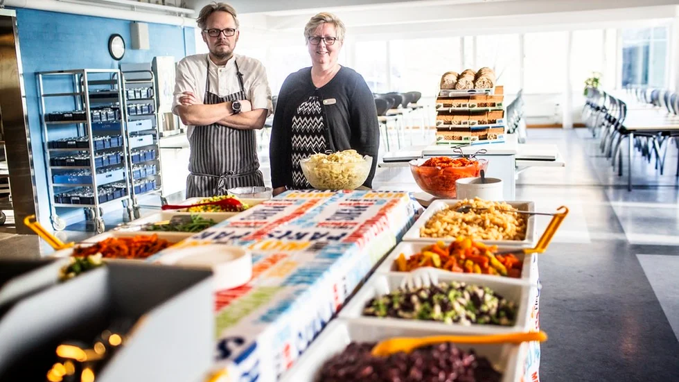 Per Kålbäck, kökschef i Flen, och måltidschef Monika Holm står vid grönsaksdisken på Stenhammarskolan som de kommande veckorna kommer att se lite annorlunda ut.