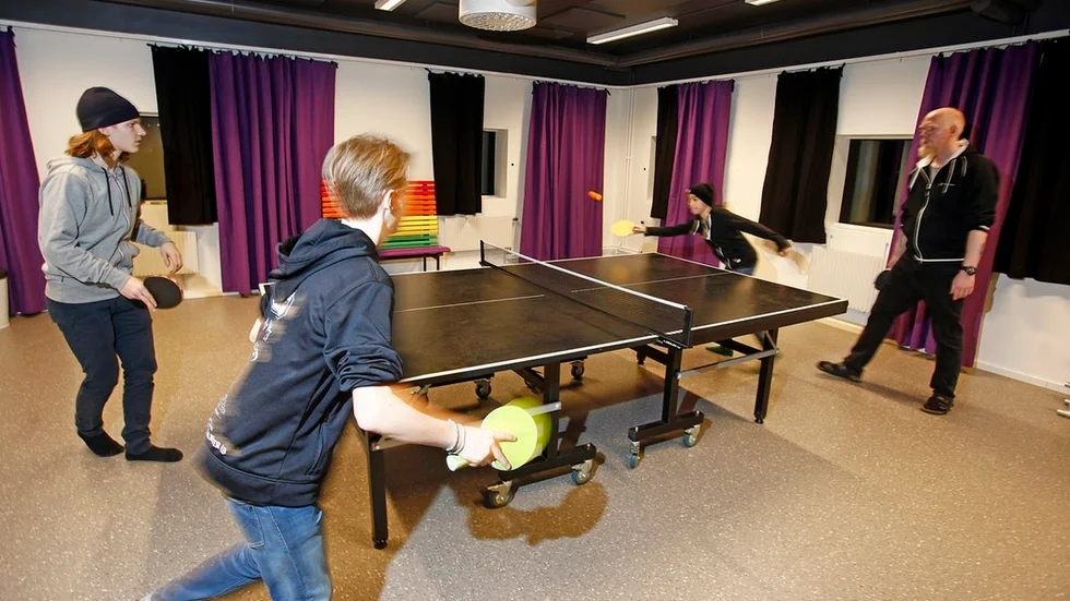 Fritidsledaren Dennis Wedin vid pingisbordet tillsammans med Lucas Ekholm, Theo Andersson och Mher Kiumgyan.