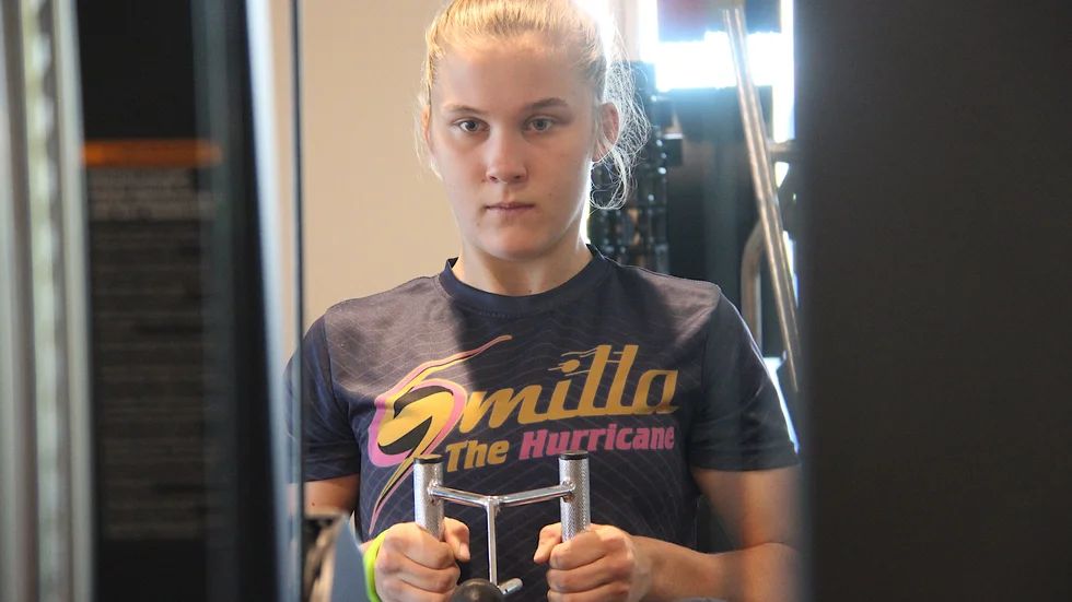 Smilla Sundell fokuserar på träningen i Pepparrotsbadets gym. När hon är hemma och hälsar på familjen i Örsundsbro vill den nykorade världsmästaren i mauy thai, thaiboxning, inte tappa styrka. Hennens räckvidd och mentala styrka har tidigt gjort henne framgångsrik i sin idrott.