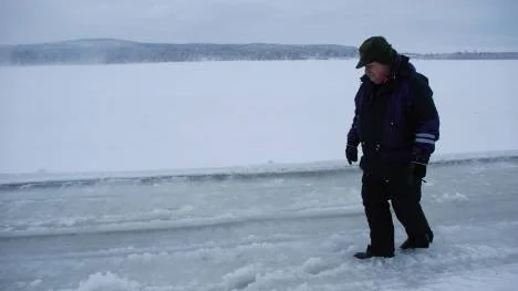 Vatten tränger upp på isen i spåren av snöslungan. Ingen fara, konstaterar Stefan Johansson efter en närmare titt.