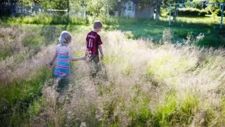 IGENVÄXT. Tindra Grundström och Jakob Ihs Wozniak går runt i det höga gräset.