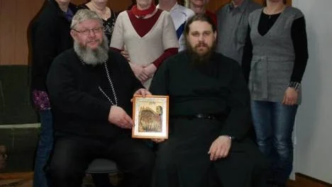 Umbagruppen från Arjeplog vid sitt senaste besök  i Ryssland. Bilden är tagen i samband med att de träffade ryske prästen fader David (sittande till höger) Stående från vänster: Rigmor Lestander,  Monika Fjellström, Gun-Britt Öberg, Gunnar Jonsson, Inga-Lill och  Assar Lestander samt tolken Elena Renberg. Till vänster om fader David  sitter Arjeplogs kyrkoherde Anders Mattson.