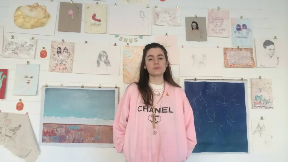 Moa Romanova Strinnholm framför sin sketchbookvägg.
"Det är sprunget ur gatukonsten och lite mer inspirerat av mina kompisar och internetkulturen, alla härliga balla brudar på internet. Den är mer personlig, det är lite dagboksvägg", säger hon.