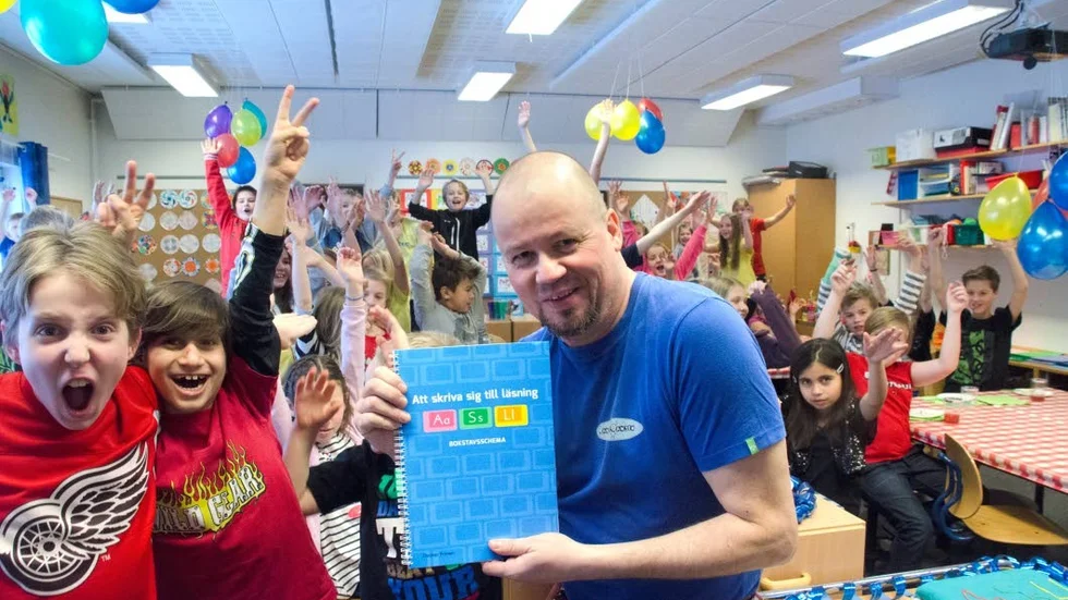 Hurra för Christer! Christer Friman med sin nuvarande klass från årskurs 1 och den gamla som nu går i fyran. Alla deltog på releasepartyt för magister Frimans läromedel för läsning och skrivning.