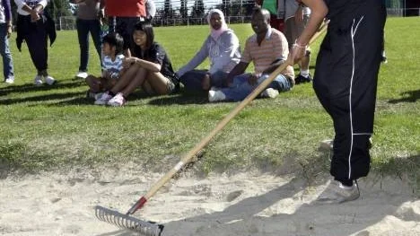 Rattana Kaewudom från Thailand krattar längdhoppsgropen slät och fin.