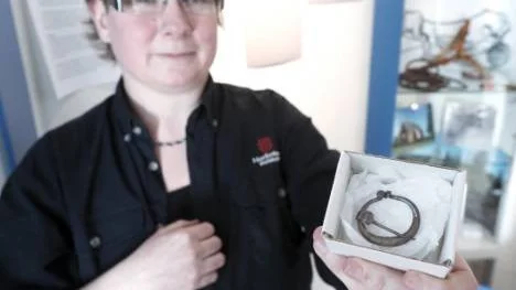 Arkeologen Carina Bennerhag visar ett silverspänne som hittades i Gråträsk 2002, vid utgrävningar efter Nasaleden.