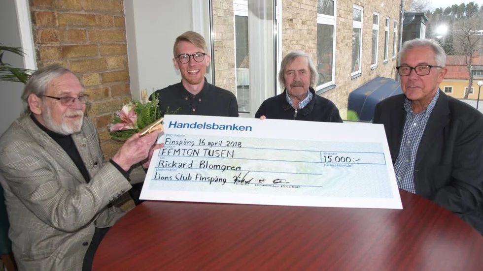 Rickard Blomgren med blommor i handen mottar Lions Clubs ungdomsledarstipendium för 2018. Lions representeras av från vänster: Bill Persson, Leif Andersson och Olov Karlsson.