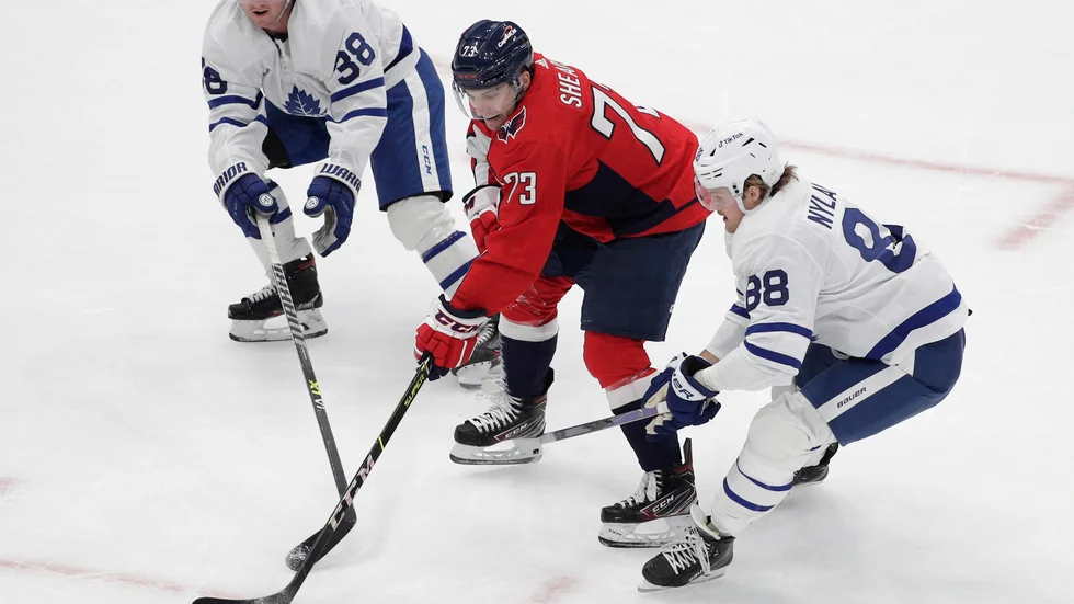 Torontos svenskar Rasmus Sandin (till vänster) och William Nylander (höger) på var sin sida om Washingtons Conor Sheary.