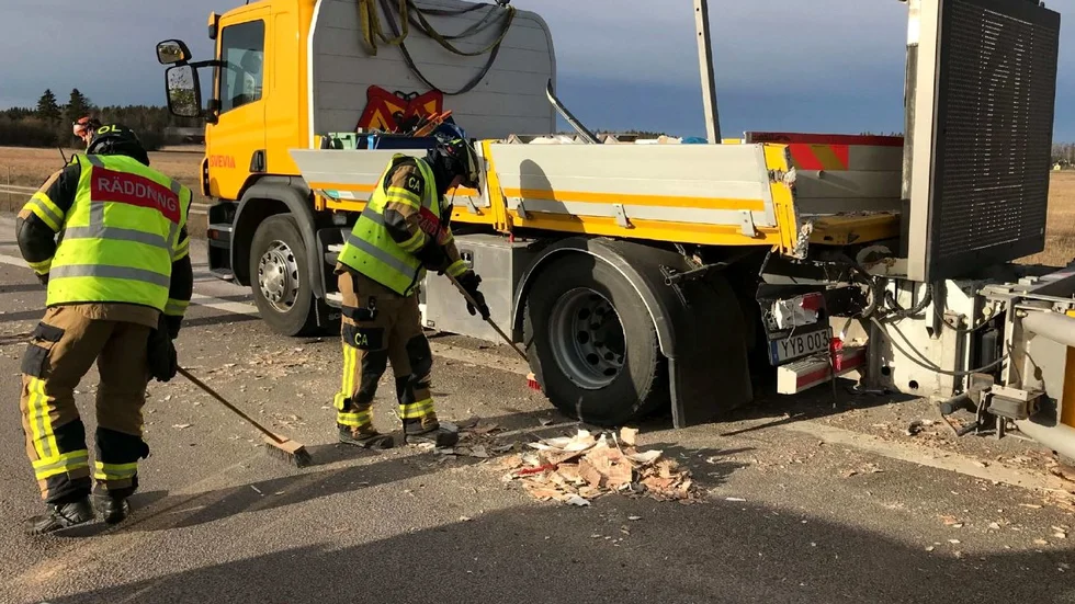 Den påkörda TMA-bilen och brandmän som sanerar olycksplatsen efter olyckan.