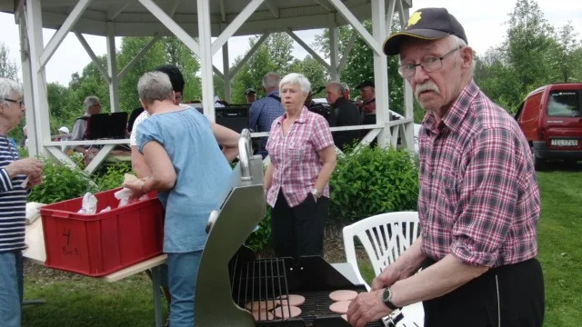 GRILLARE. Yngve Lundqvist vid grillen. I bakgrunden bland annat Naimi Wikström.