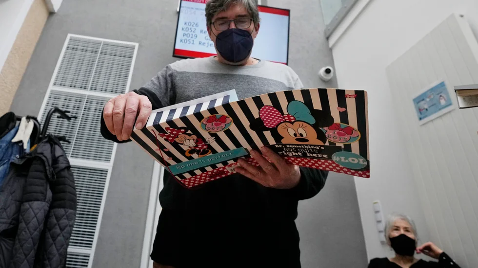 56-årige Andrzej Wiazecki i Warszawa lägger in sitt vaccinbevis i en mapp efter att ha fått tredje dosen häromdagen.