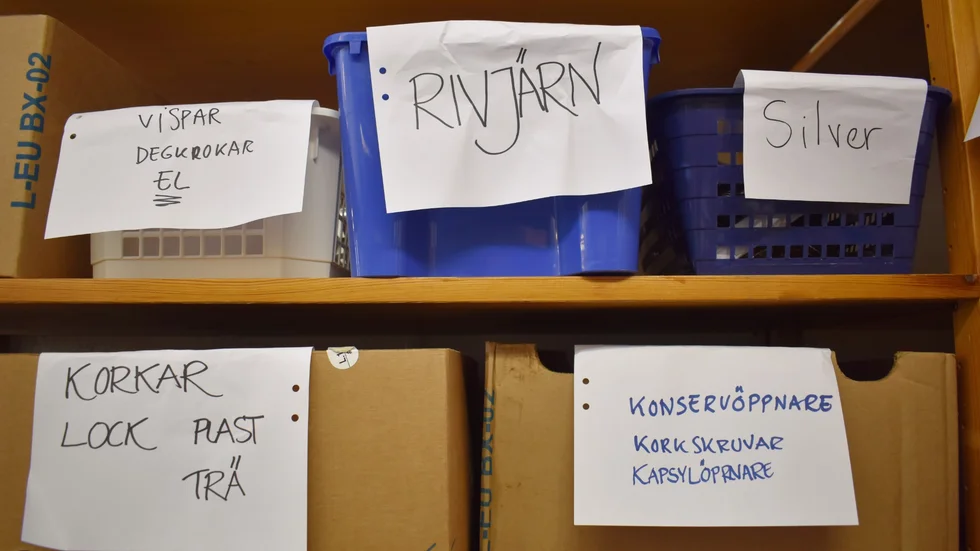 Tänk att det finns så många prylar i folks kök. Här sorteras nu sakerna upp, och en måttlig mängd i taget bärs ner till butiken. 