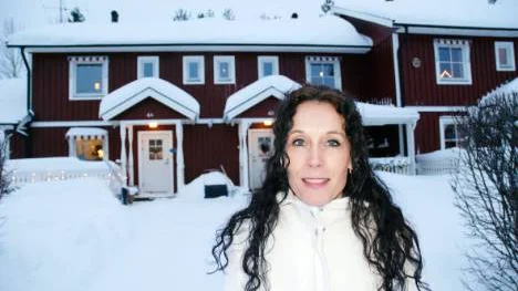 Annette Fager utanför sin bostad i Svartbjörnsbyn." Jag har själv varit med i bostadsrättsföreningen i tolv år innan jag för några år sedan engagerade mig i styrelsen. I dag är jag ordförande."FOTO: Lena Leffler