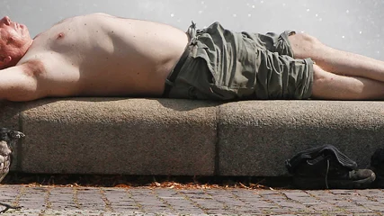 A man enjoys the sun next to a fountain on a hot afternoon  in Warsaw, Poland, Monday, July 29, 2013. The temperature in the south of Poland reached 40 degrees Celsius (104 Fahrenheit). (AP Photo/Czarek Sokolowski)