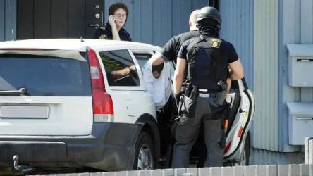 Rånare gripen. Nationella insatsstyrkan placerar en av de gripna männen i en civil bil. En av männen anhölls senare                                misstänkt för det brutala väpnade rånet i Bredviken. FOTO: Pär Bäckström