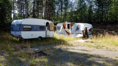 Två övergivna husvagnar står på tomten.