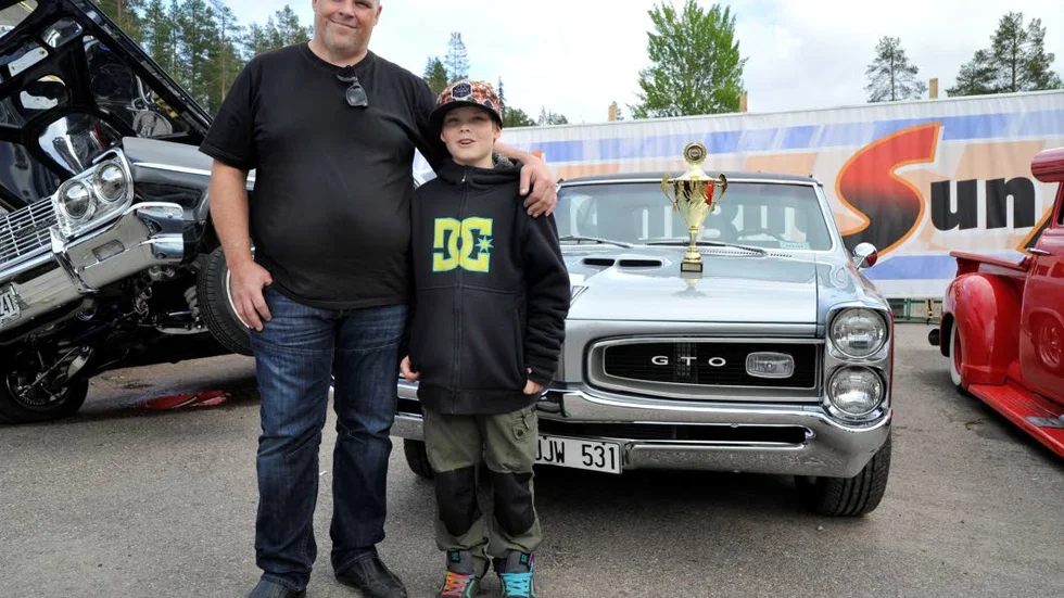 Mikael Broström med sonen Dennis framför deras silvergrå Pontiac GTO från 1966. Tre år har Mikael jobbat med renovering - det resulterade i en fin prisbuckla.