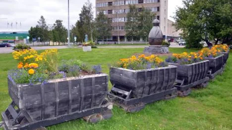 Blomstersmyckat malmtåg i centrala Malmberget. Jerry Isakssons Gruvgubbe och en av LKAB:s mätplintar i bakgrunden.FOTO: Marie Ridderström