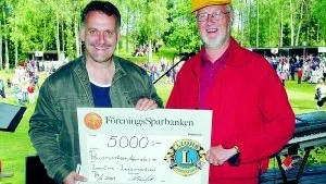 Anders Bengtsson tar emot en check på 5000 kronor för arbetet med Polustuståget som man fått av Lions.