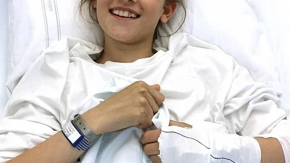 Clara Lindblom, 12, kostar på sig ett leende från sjuksängen trots den svåra skadan som drabbade henne under fotbollsturneringen i Piteå.