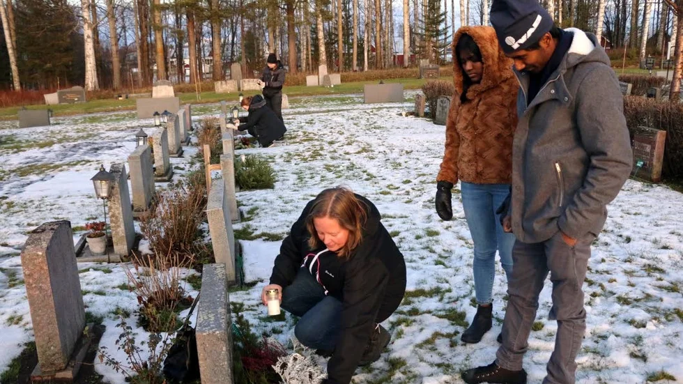 Carola, Mattias och Tina Johansson tände ljus på Carolas farmor och farfars grav i Hortlax. "Det är mysigt att vara här" säger Carola.