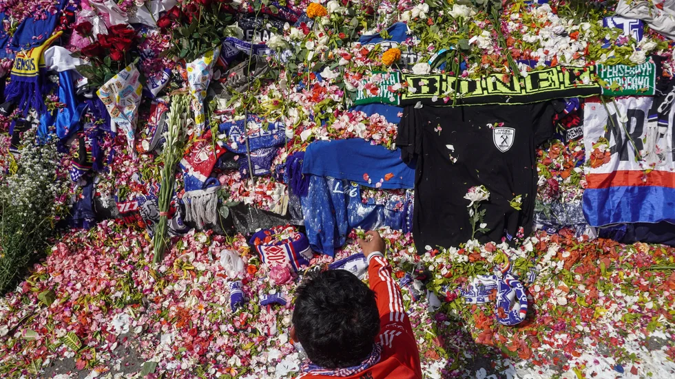 En man placerar ut blommor utanför Kanjuruhan Stadium.